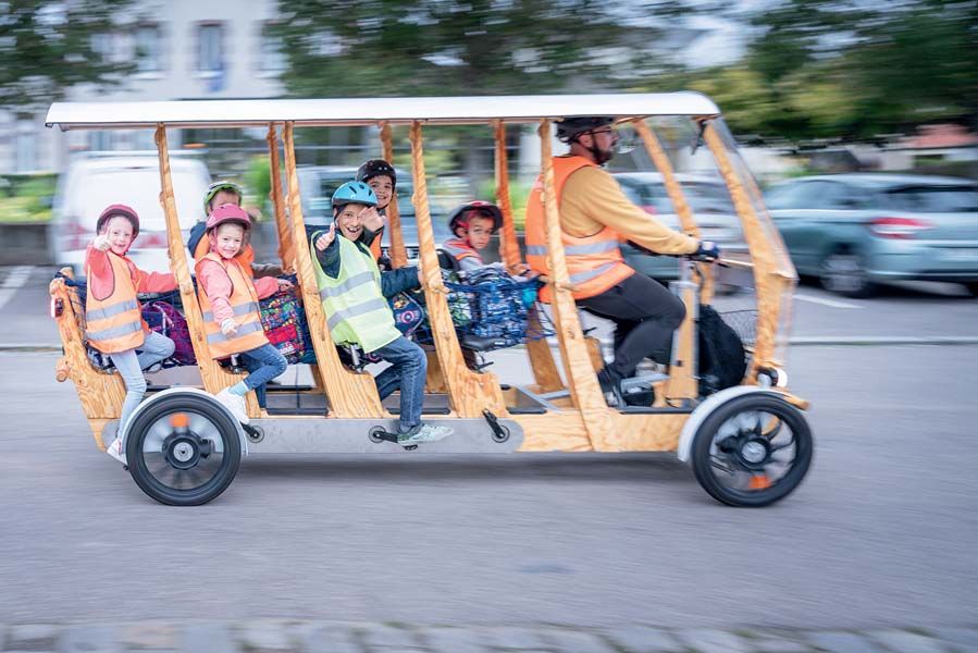 Casques sur la tête, les enfants pédalent pour un trajet domicile-école à bord du &#171; S'Cool Bus &#187;, qui peut emprunter les pistes cyclables.